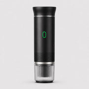 Tazzi portable espresso maker in matte black, front view, assembled with the ribbed clear cup attached