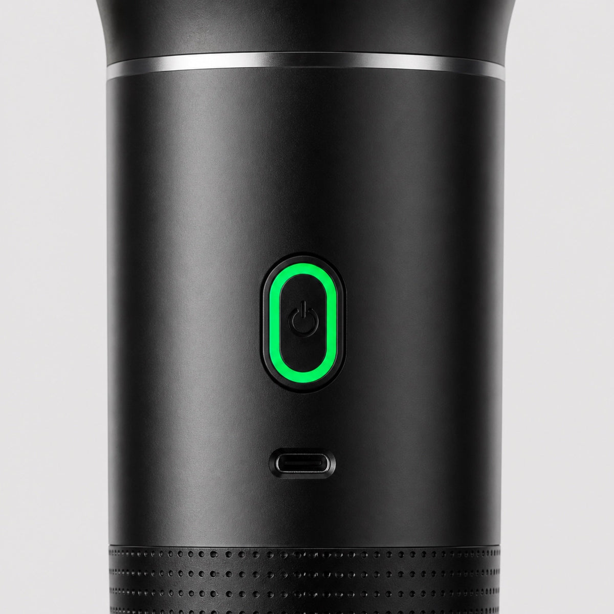 Close-up of the Tazzi single pill-shaped button with green LED ring and the USB-C charging port below it