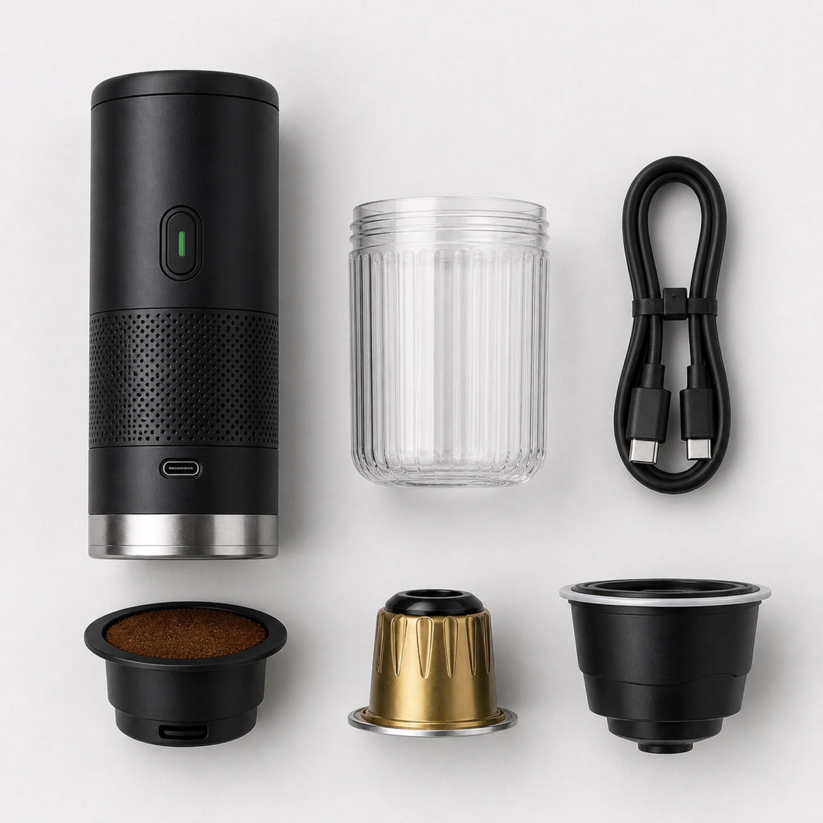Tazzi components laid out from above: the black body, the ribbed clear cup, a USB-C cable and the three adapters