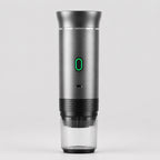 Tazzi portable espresso maker in brushed metal, front view, assembled with the ribbed clear cup attached